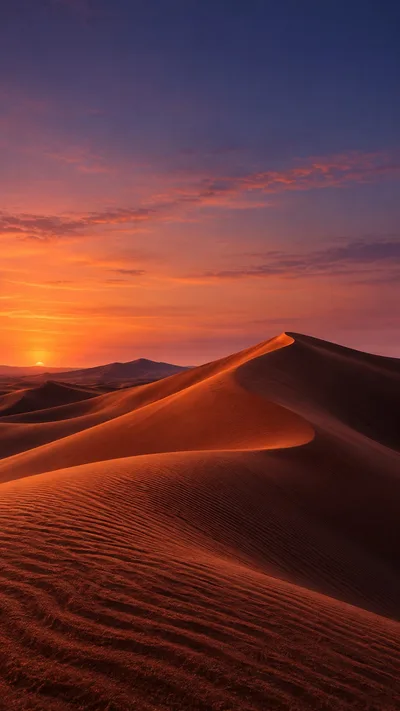 Terracotta dunes catch an amber rim beneath a rose and indigo dusk.